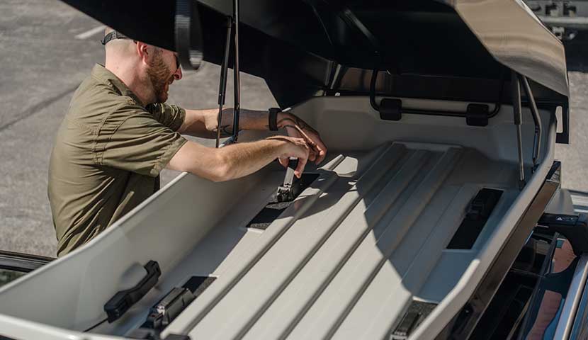 Man adjusting a roof cargo rack on a vehicle