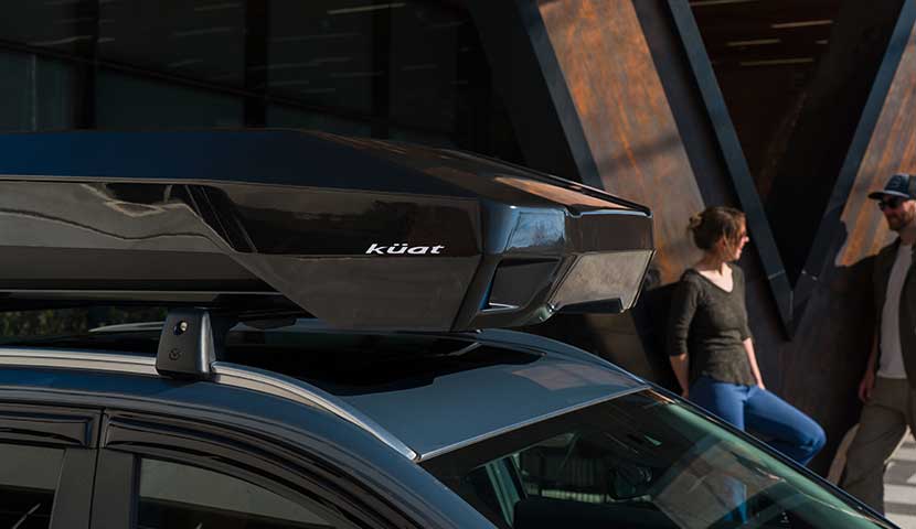 Kuat roof rack cargo box system on a car with people in the background
